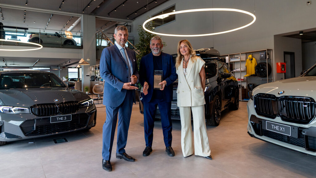 Vediamo 3 persone all'interno della concessionaria durante la consegna del premio Top Experience Award 2026